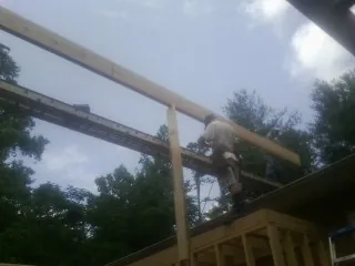 Carpenter setting a ridge beam over a new addition frame — Ice Dam Removal by Roofing Brothers in Chester Heights