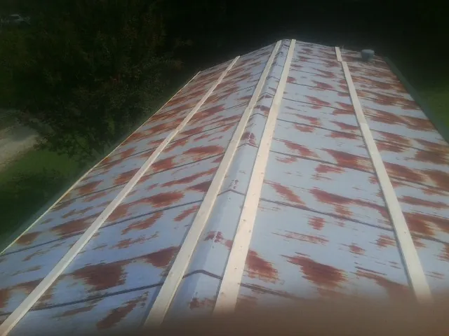 Rusted metal roof panels with new wood purlins before replacement — Storm Damage Roof Repair in Chester Heights by Roofing Brothers