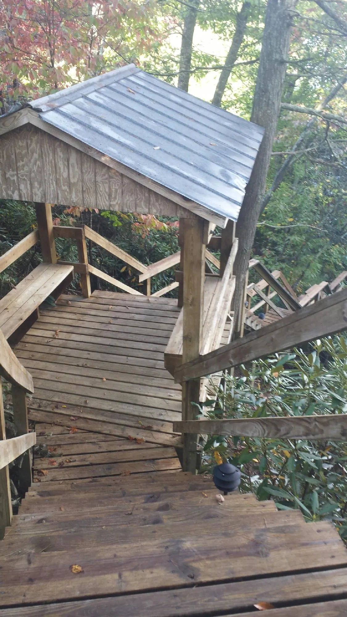 Metal roofed shelter over wooden steps on a wooded walkway — Skylight Repair & Installation work by our crew in Chester Heights