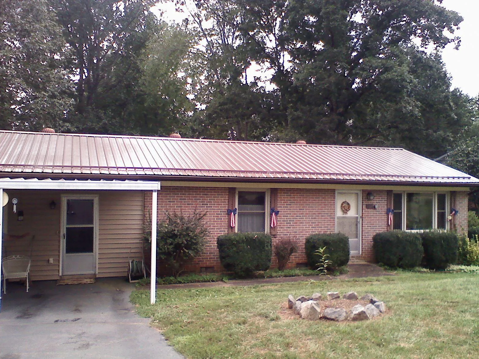 Bronze metal roof and carport on a brick ranch home — Roof Repair work by our crew in Chester Heights